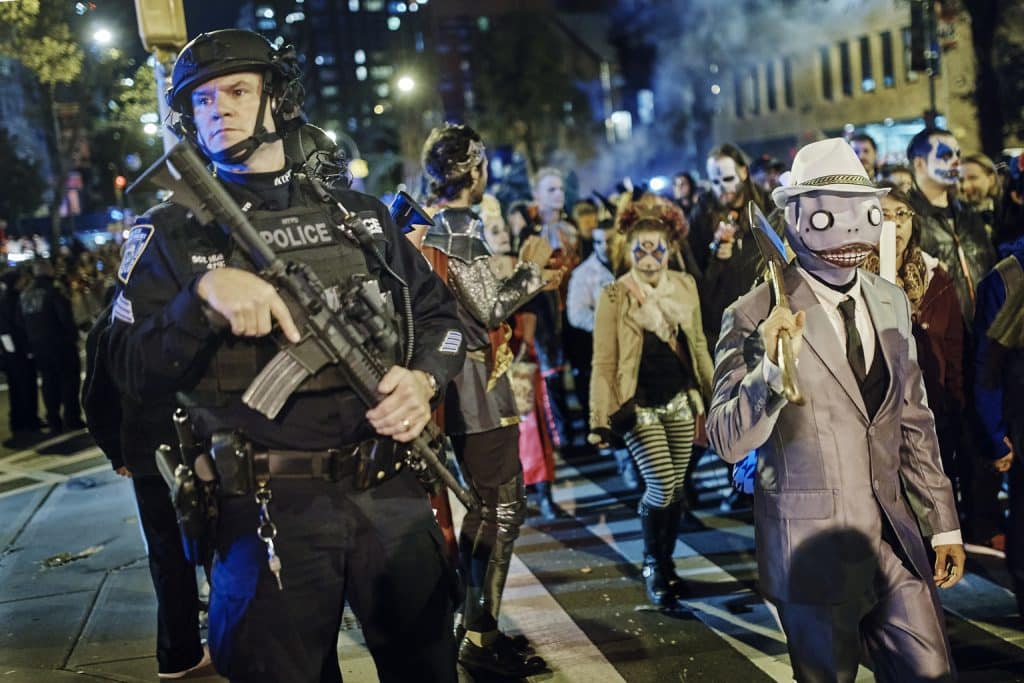 Heavily armed police guard as revelers march during the Greenwich Village Halloween Parade, Tuesday, Oct. 31, 2017, in New York. New York City’s always-surreal Halloween parade marched on Tuesday evening under the shadow of real fear, hours after a truck attack killed several people on a busy city bike path in what authorities called an act of terror. (AP Photo/Andres Kudacki)
