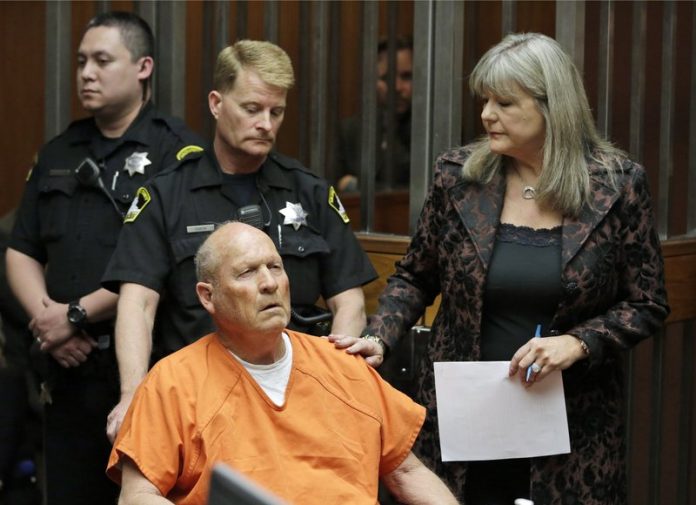 Joseph James DeAngelo, 72, who authorities suspect is the so-called Golden State Killer responsible for at least a dozen murders and 50 rapes in the 1970s and 80s, is accompanied by Sacramento County Public Defender Diane Howard, right, as he makes his first appearance, Friday, April 27, 2018, in Sacramento County Superior Court in Sacramento, Calif. (AP Photo/Rich Pedroncelli)